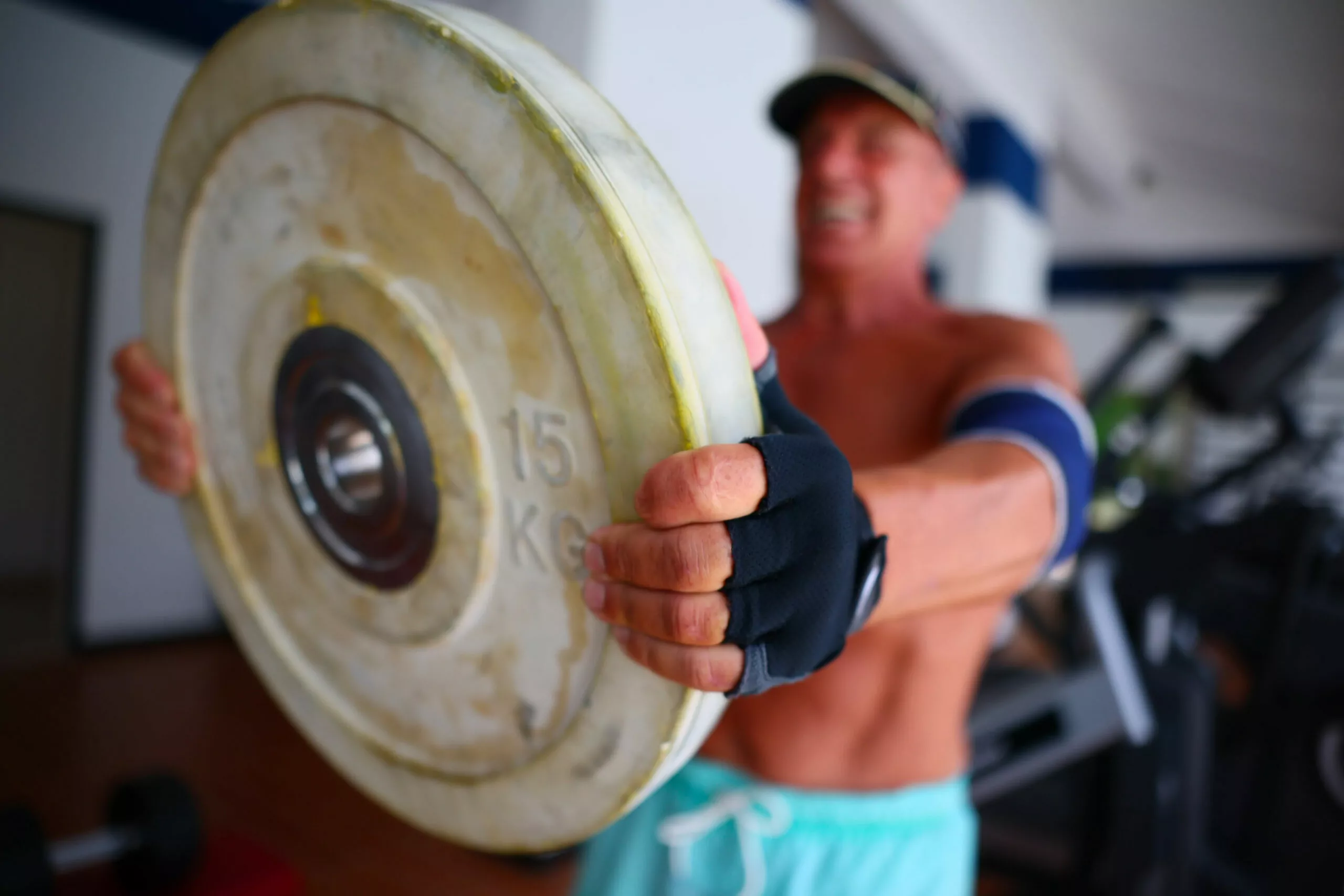 sportivo che si allena in palestra con i pesi