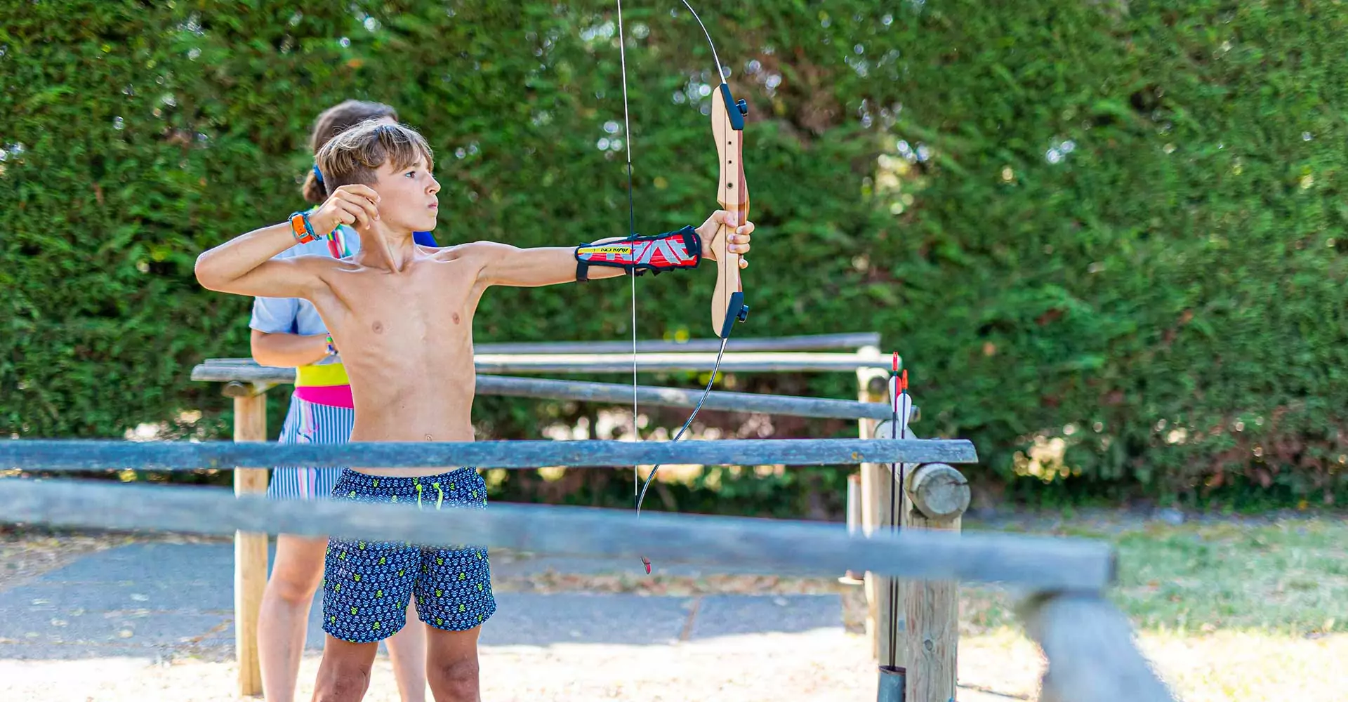 bambino che tira con l'arco nel campo del villaggio san francesco