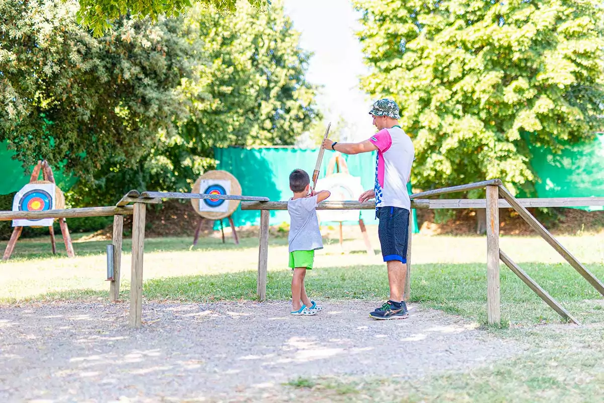 Villaggio sportivo - bambino e istruttore al tiro con l'arco