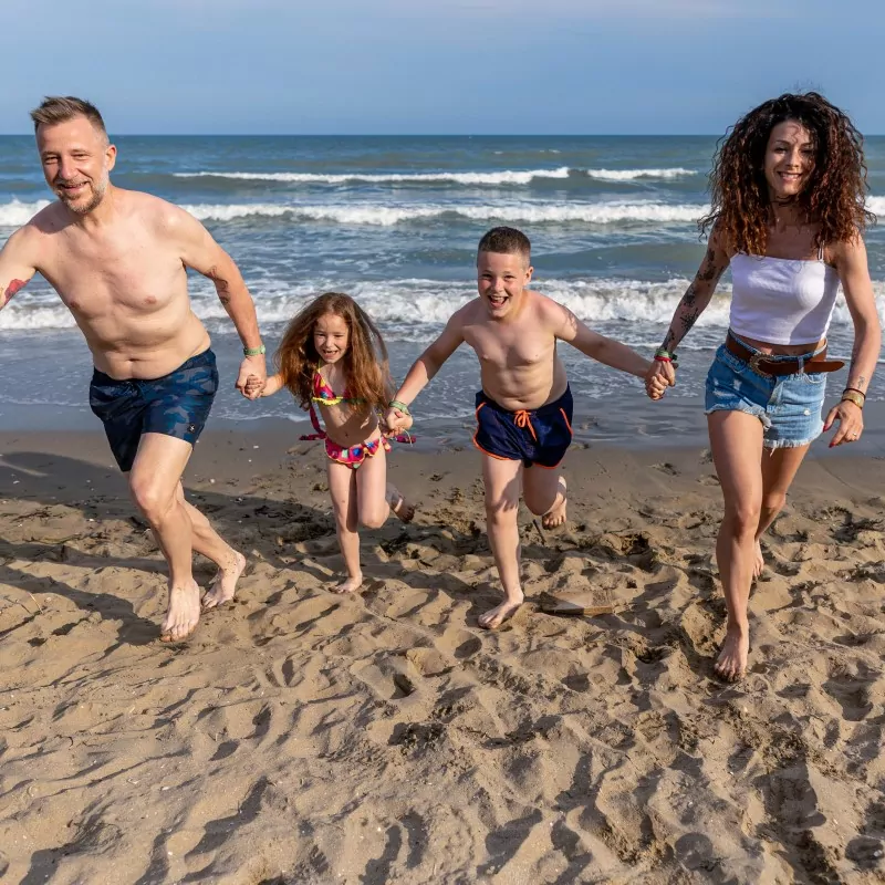 famiglia che corre in spiaggia al camping san francesco di caorle